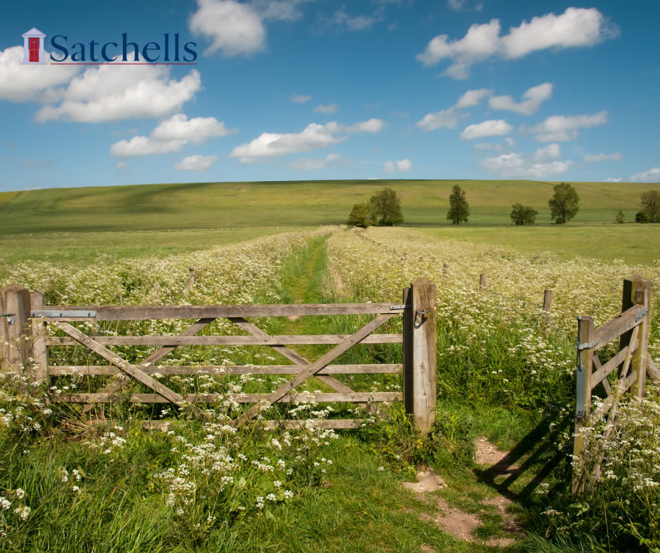 Wooden field gate and footpath through village countryside